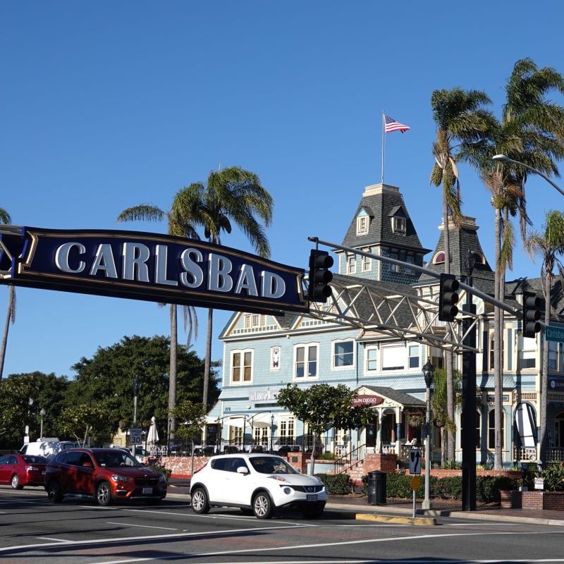 Carlsbad sign and swaying palm trees