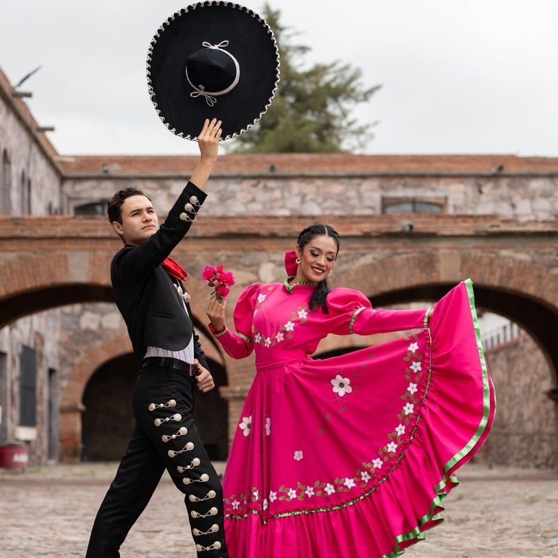 Latin Couple Wearing Traditional Mexican Attire As They Dance In Old Town Guadalajara, Mexico, Latin America