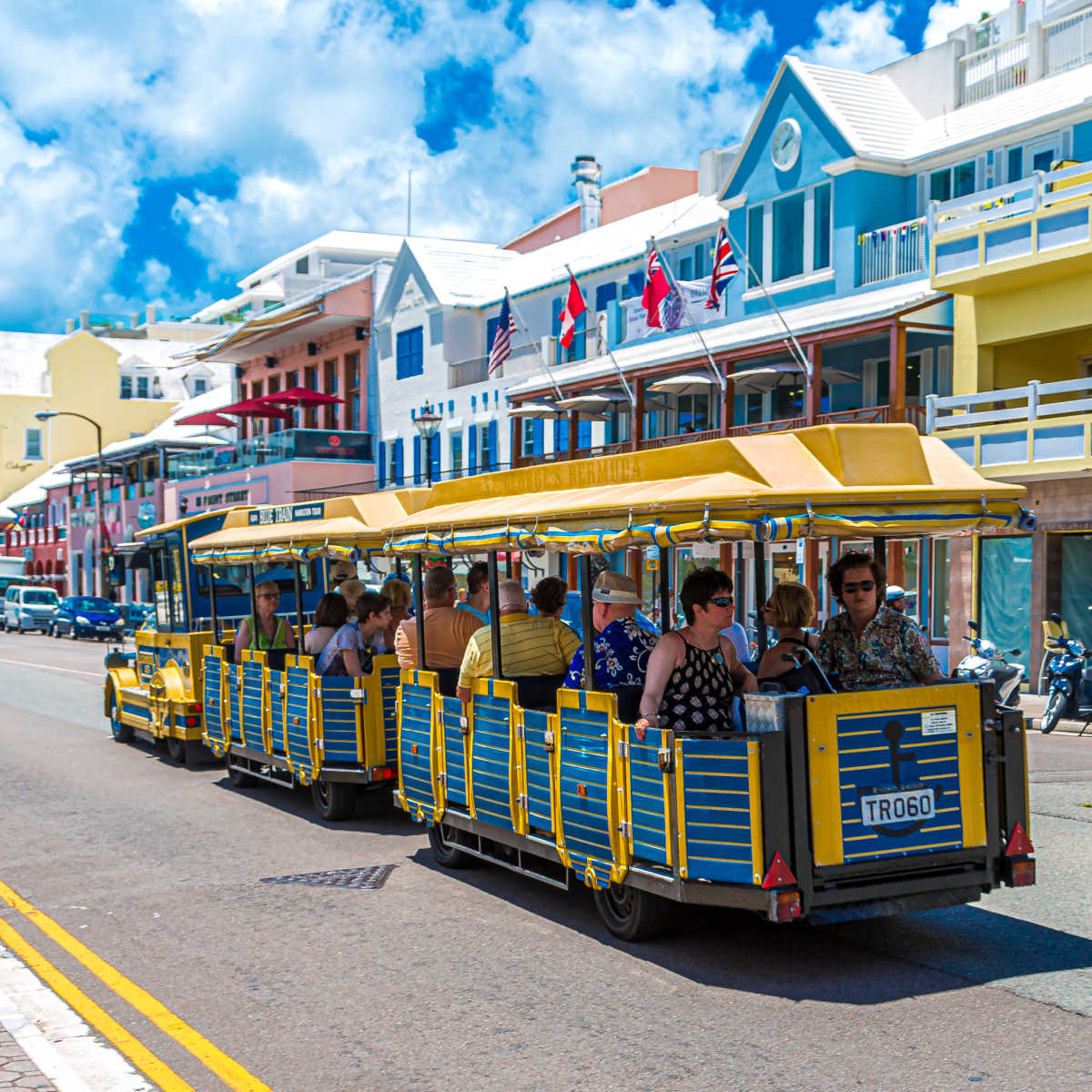 Tourists riding through Hamilton, Bermuda on nice day