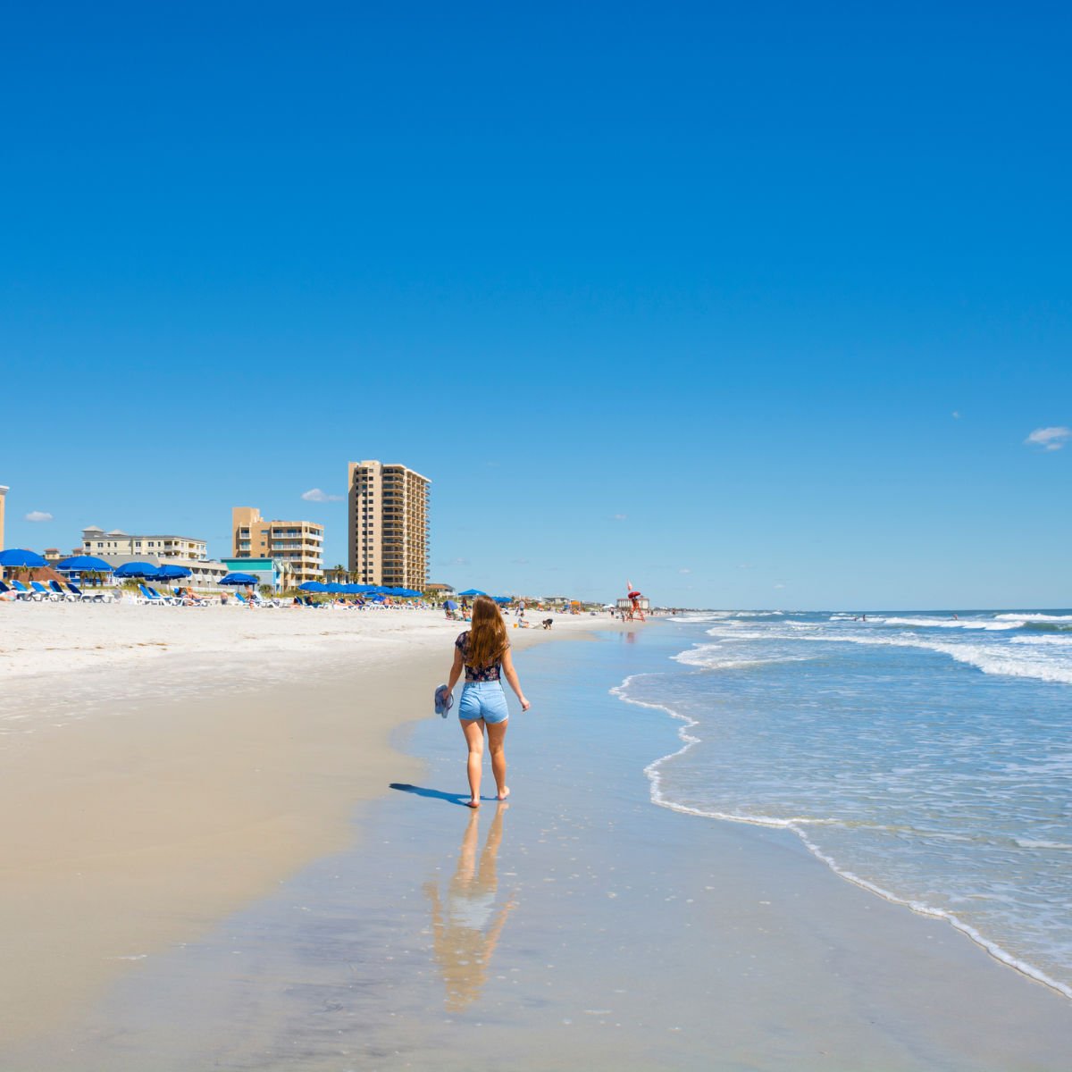 Woman walking along beach outside Jacksonville, FL