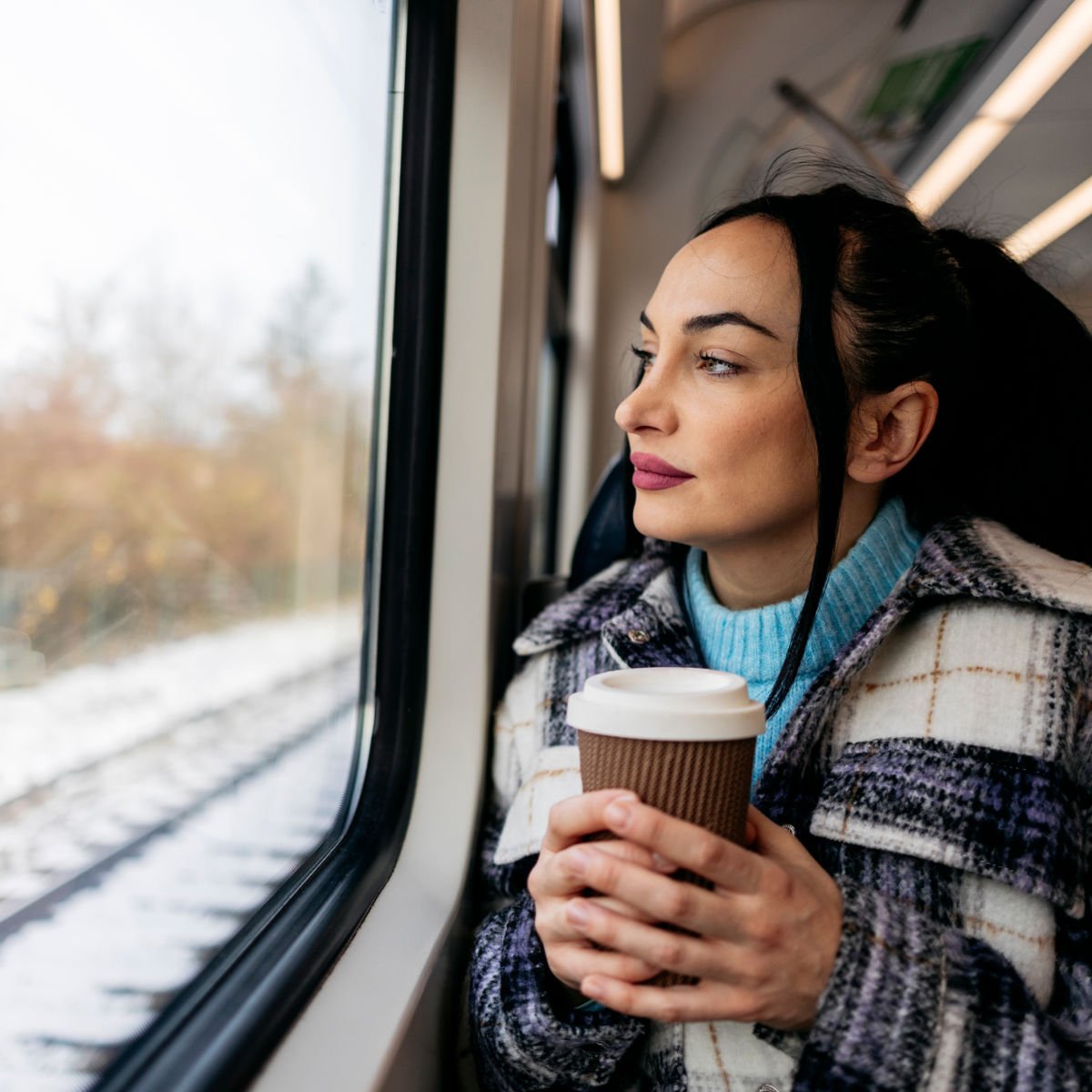 Woman Drinking Coffee As She Travels On A Train