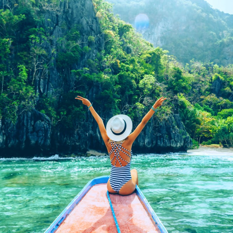 woman in hat on a boat in El Nido, Palawan, Philippines