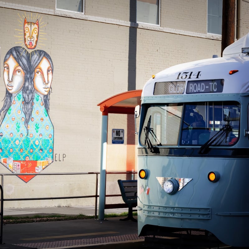 El Paso trolley passing street mural showcasing local heritage