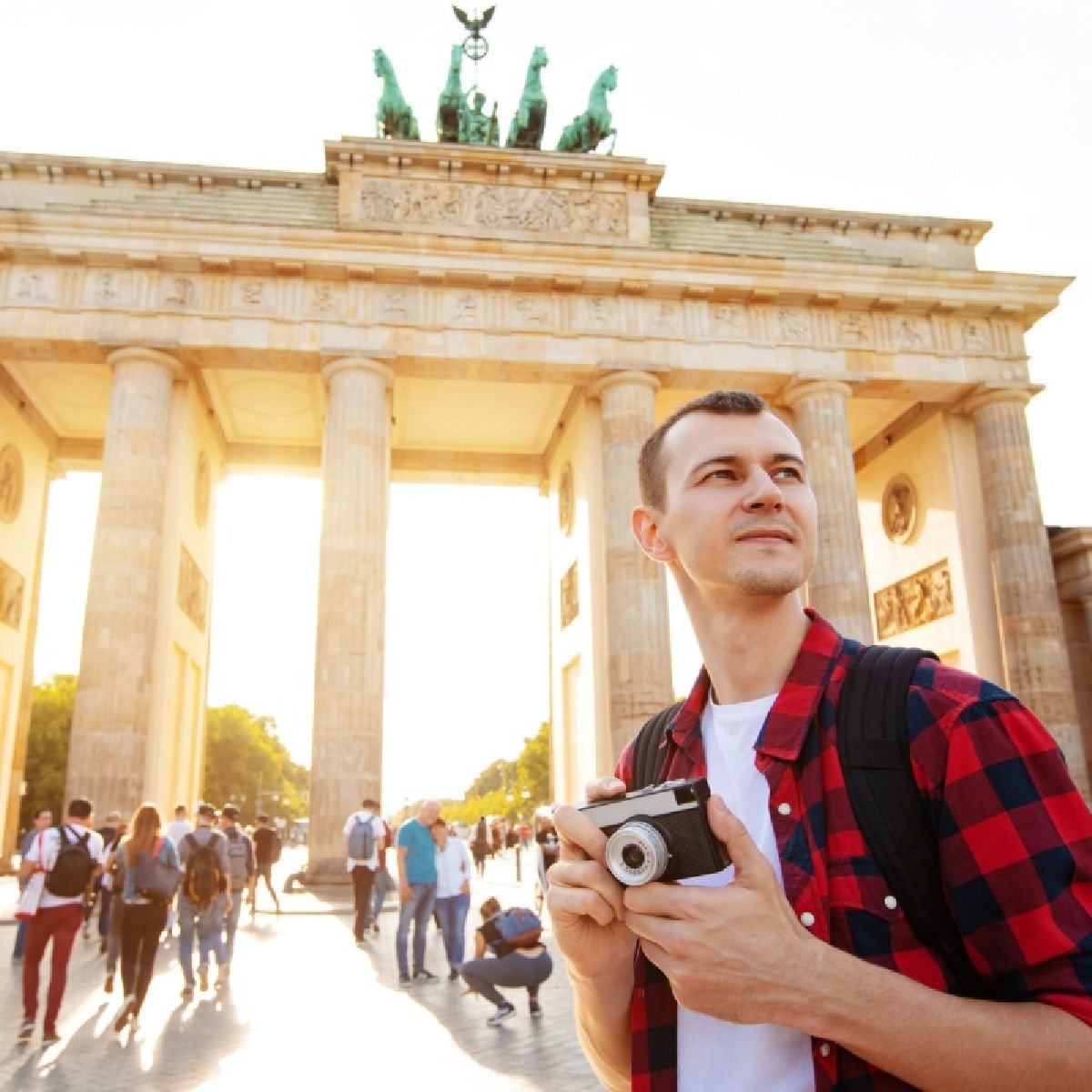 tourist man with camera in front of Brandenburg Gate, Berlin, Germany