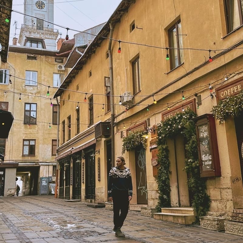 Young Man Walking A Hidden Court In Lviv Old Town, Ukraine