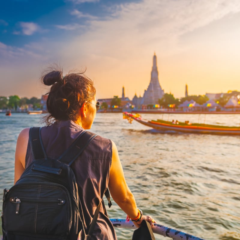 Tourist Admiring The View Of A Temple Across Bangkok River, Bangkok, Thailand, Southeast Asia