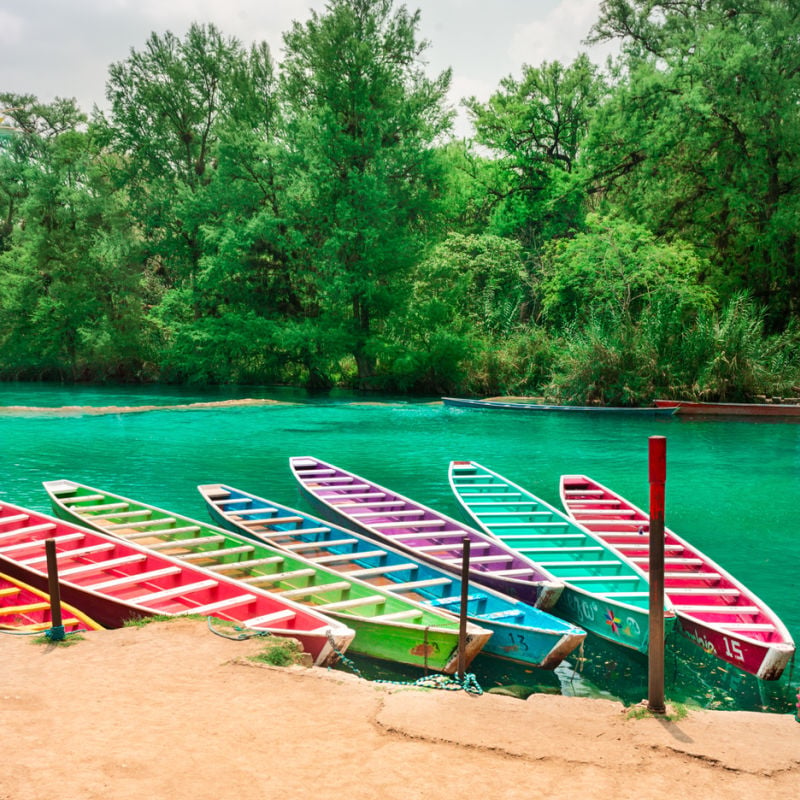 Six colorful wooden boats on river in San Luis Potosi