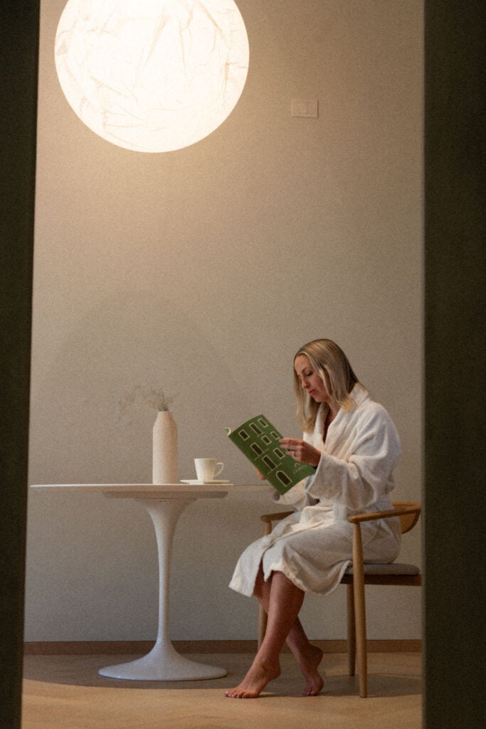 Woman in Palazzo Ciopeta reading about the property under globe light