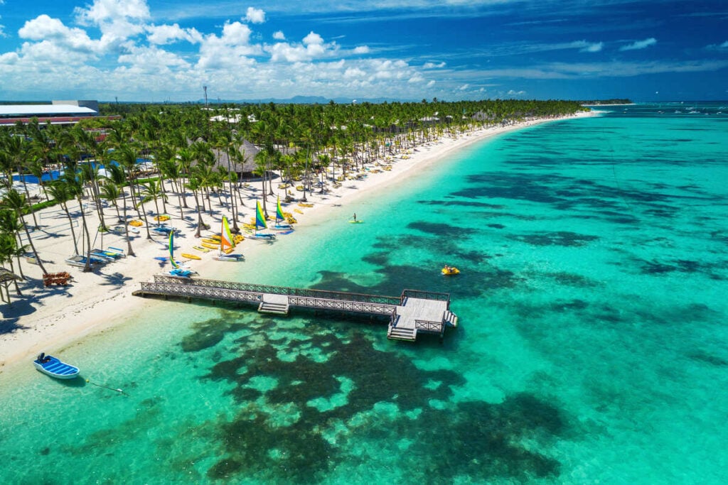 Palm trees and white sand beach meet clear blue waters in Punta Cana Dominican Republic